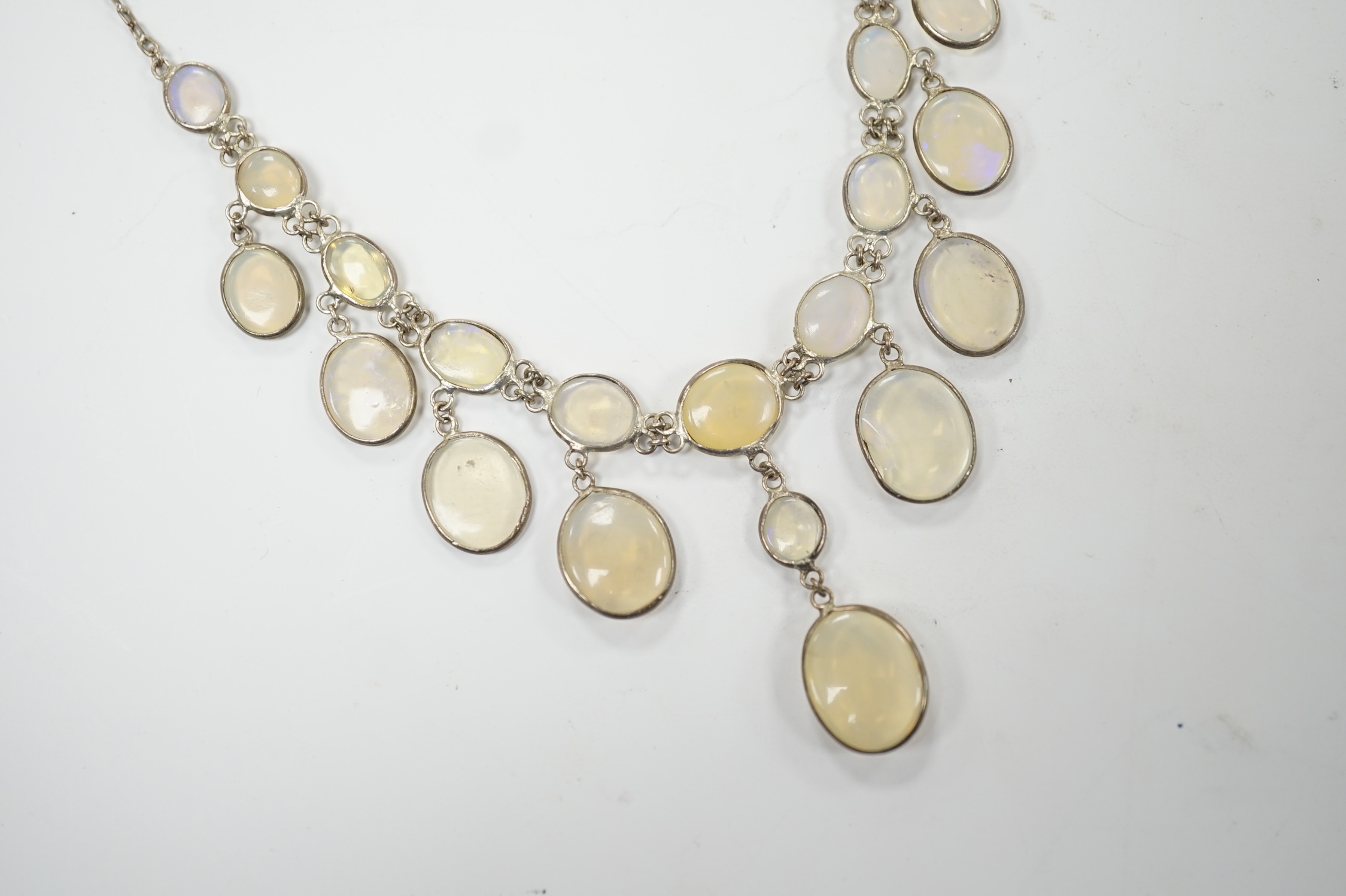 A white metal and graduated cabochon moonstone set drop necklace, 46cm. Fair condition